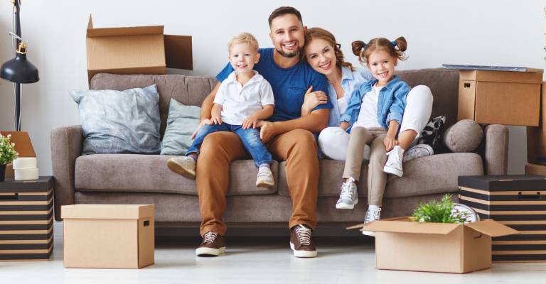 Gelukkig gezin vader moeder en kinderen verhuizen en pakken dozen uit